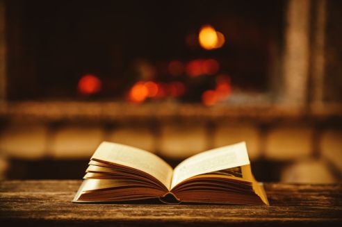 Open book by the Fireplace with Christmas ornaments. Open storyb